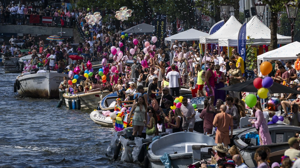 Drukte bij Amsterdamse grachten voor Canal Parade, eerste boten vertrokken