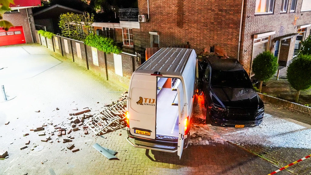 Werkbus ramt auto door gevel huis Geldrop