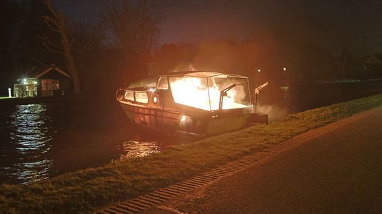 Brandend plezierjacht drijft af over de Vliet