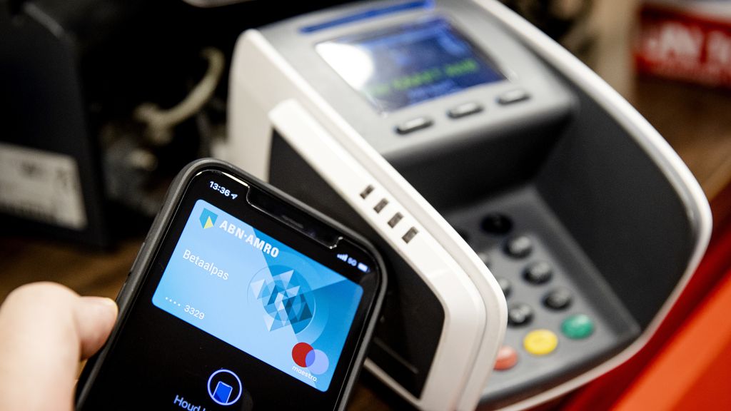 Mobiele telefoon haalt de contactloze betaalpas in aan de kassa