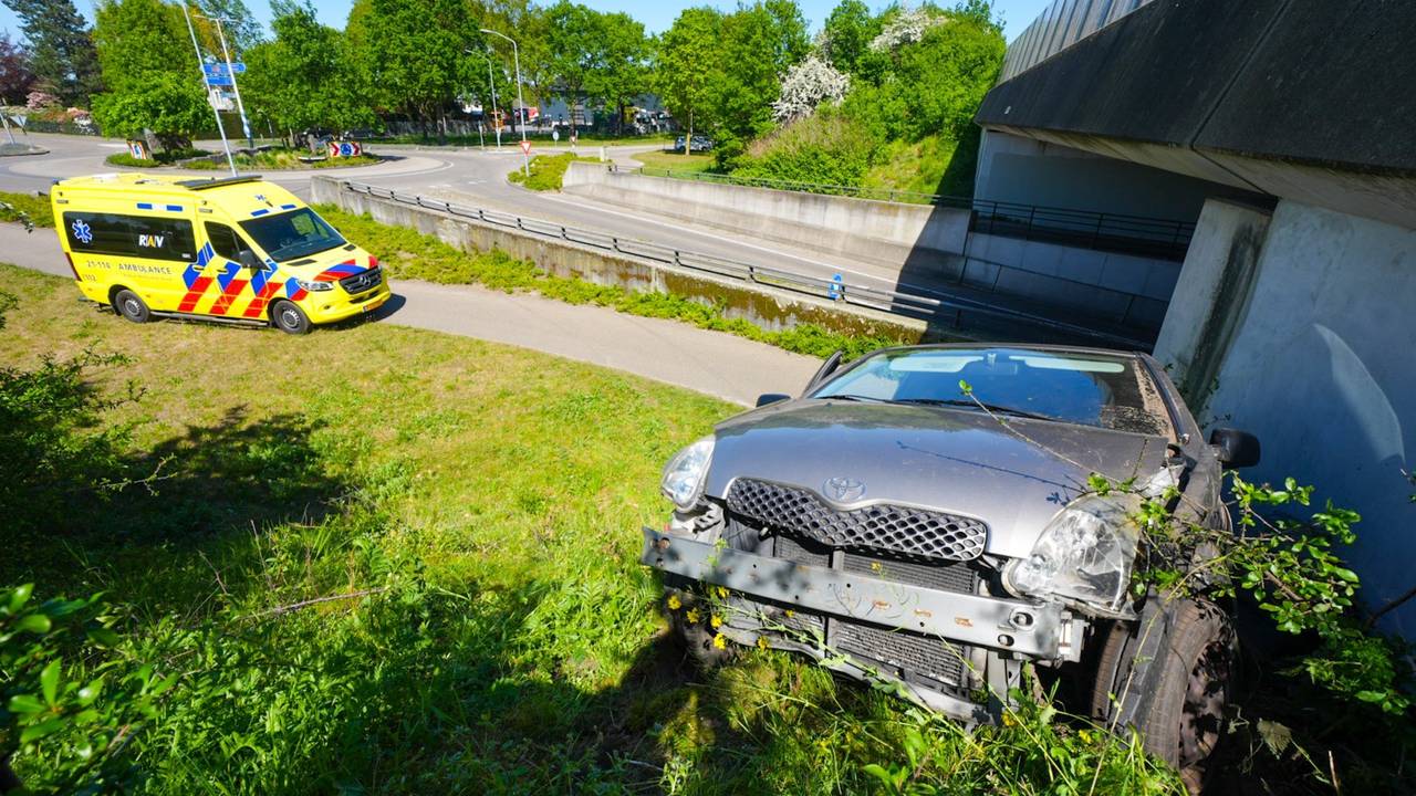 Auto wordt gelanceerd op rotonde en belandt schuin op talud, man gewond